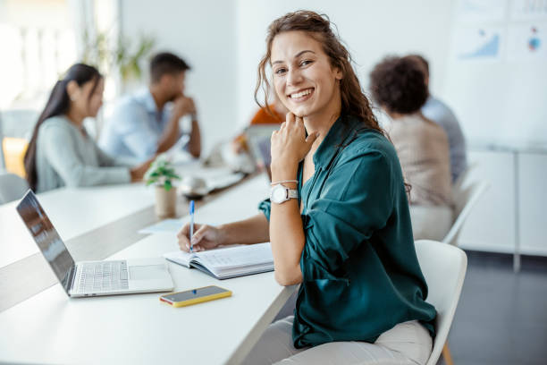 Businesswoman smiling in office meeting, representing the benefits of an IFZA Free Zone License for businesses.