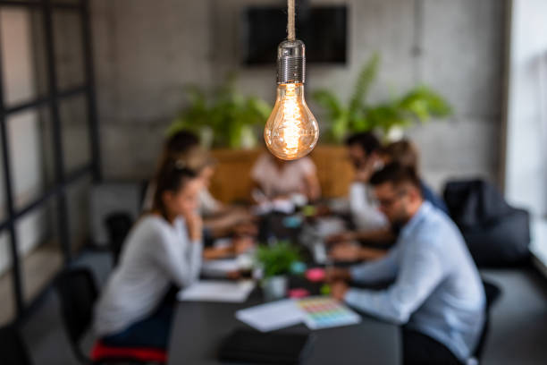 A light bulb representing innovative ideas with professionals discussing investment risks and opportunities in Dubai.